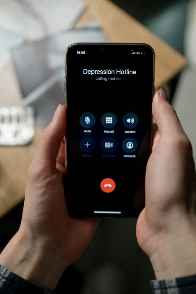 A person uses a smartphone to call a depression hotline for mental health support.
